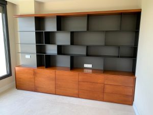 Librería a medida con módulos inferiores cerrados y estanterías superiores abiertas