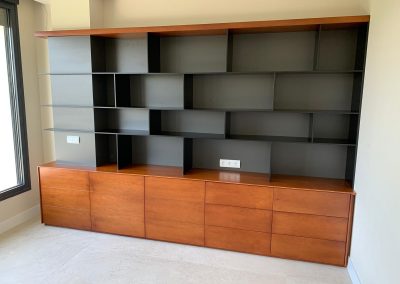 Librería a medida con módulos inferiores cerrados y estanterías superiores abiertas