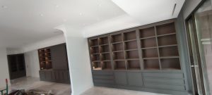 Librería mural a medida ocupando pared completa en salón