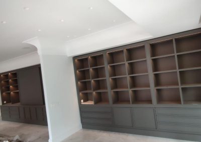 Librería mural a medida ocupando pared completa en salón