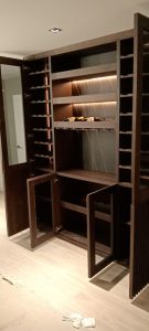 Librería a medida tipo vinoteca con estantes para botellas