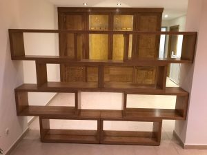 Librería a medida de madera natural utilizada como separador de ambientes en vivienda de Madrid