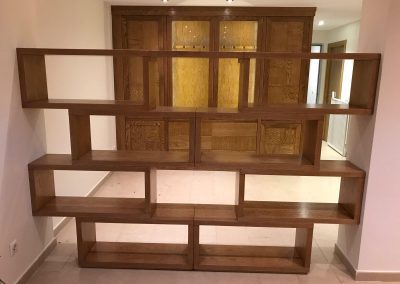 Librería a medida de madera natural utilizada como separador de ambientes en vivienda de Madrid